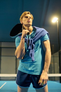 Genç bir sporcu atletizm kıyafetleriyle meydan okuyacak bir Padel maçına hazırlanıyor..