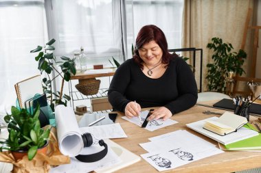 Yaratıcılık pratiği yapan, güzel bir kadın sanat stüdyolarında çalışma alanını davet ederek mutlu bir şekilde çizim yapıyor..