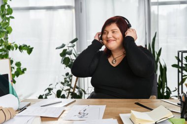 Güzel bir kadın çizimler ve yeşilliklerle dolu bir sanat stüdyosunda yaratıcı anından zevk alır..