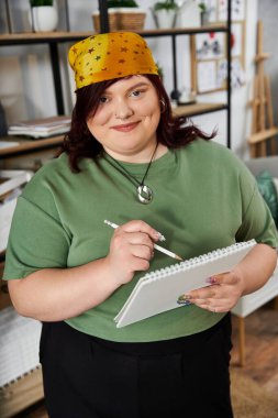 Zarif bir kadın şık stüdyosunda resim çizerken sanatsal bir ifade takınır..