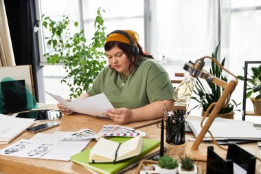 Güzel bir kadın sanatı üzerinde düşünceli bir şekilde çalışıyor. Parlak, bitki dolu bir stüdyoda..