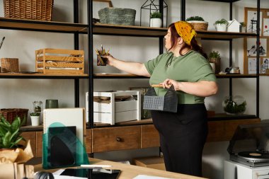 Bir kadın, canlı ve ilham verici stüdyosunda sanat malzemeleri organize eder..