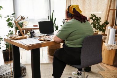 Güzel bir kadın, bitkilerle çevrili şık sanat stüdyosunda yaratıcı bir sürece girişir..