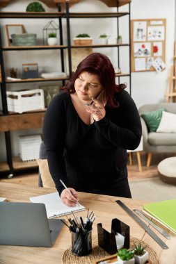 Güzel bir kadın sanat stüdyosunda yaratıcı çalışmalarına odaklanmış fikirler çiziyor..