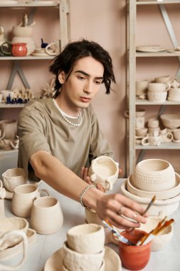 Sanat eserleriyle dolu ilham verici bir stüdyonun ortasında çömlekçilik yapan yaratıcı bir birey..