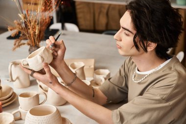 Şık bir adam, sakin ve ilham verici bir stüdyoda çömlek şekillendirir..