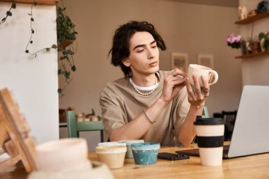 Büyüleyici bir çömlek atölyesinde seramik bardak yapmaya odaklanmış şık bir adam..