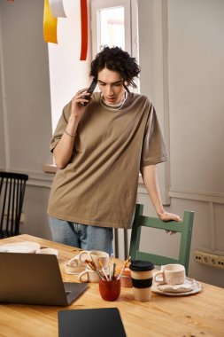 Yaratıcı adam telefonda düşünceli bir sohbetin tadını çıkarırken seramik üzerine çalışır..