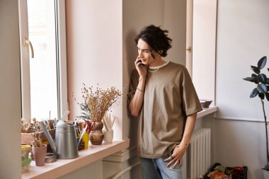 Şık bir adam, çömlek aletleri ve ilhamla çevriliyken yaratıcı düşüncelerle meşgul olur..