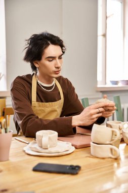 Parlak ve ilham verici bir stüdyo alanında eşsiz çömlek parçaları yapmaya odaklanmış yetenekli bir adam.