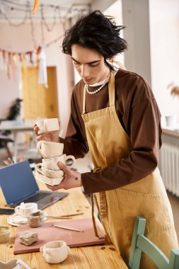 Çekici bir adam el yapımı çömleği yaratıcı araç ve malzemeler arasında ustalıkla düzenler..