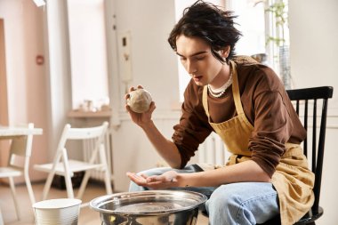Şık bir adam sanat ve zanaata adanmış ilham verici bir çömlek atölyesinde kil kalıplarını ustalıkla şekillendirir..