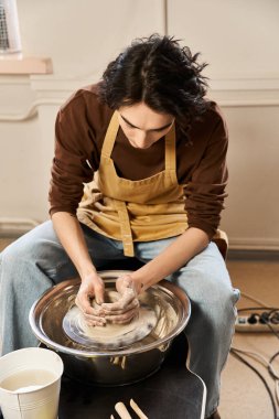 Yakışıklı adam parlak ve ilham verici bir çömlek atölyesinde seramik yontmaya odaklanıyor..