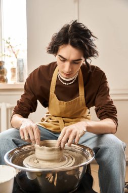 Modaya uygun bir adam çömlek çarkında kil kalıp, sanatsal yaratım ve ifade daldırır.