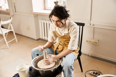 Yetenekli bir adam, sakin bir stüdyoda yaratıcılığa dalmış kili çömleğe dönüştürmeye odaklanmış..