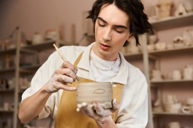 Seramik yaratıcılığıyla ilgilenen yakışıklı bir adam, canlı bir stüdyoda sanatsal yetenekler sergiliyor..