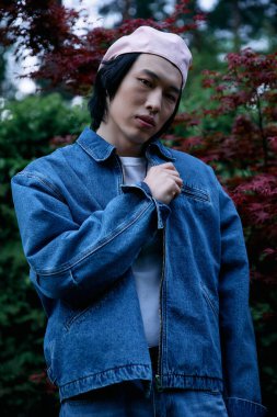 Genç Asyalı bir adam yemyeşil bir kotun içinde rahatça poz veriyor..