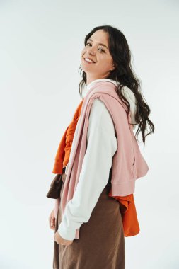 Genç bir kadın eşsiz tarzını katmanlı giysileri ve sıcak bir gülümsemesiyle sergiliyor..