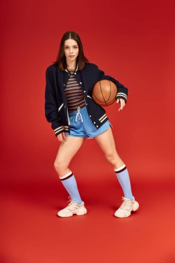 Genç ve güzel bir kadın modaya uygun spor kıyafetlerine güveniyor, harekete hazır..