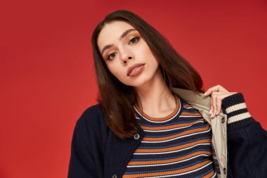 Genç kadın canlı kentsel bir ortamda canlı bir kıyafet ile canlı bir stil sergiliyor..