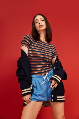 Genç bir kadın modaya uygun kıyafetlere, etkileyici pozlara ve çekiciliğe güveniyor..