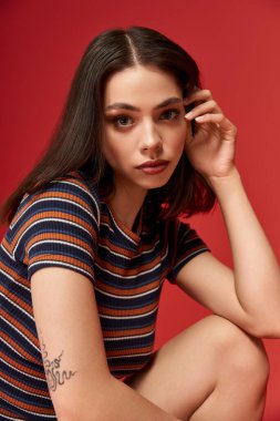 Zarif genç bir kadın şık çizgili pozlar veriyor..