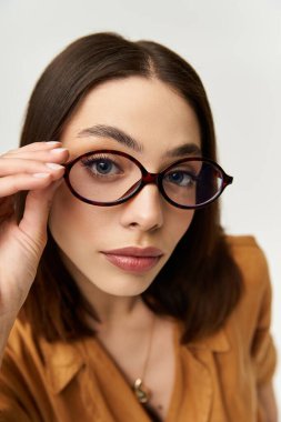 Genç, güzel bir kadın gözlüklü poz veriyor, zarif ve eşsiz bir moda yeteneği var..