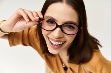 Genç bir kadın kendine güven ve cazibe saçar, şık kıyafetler giyer ve neşe içinde poz verir..