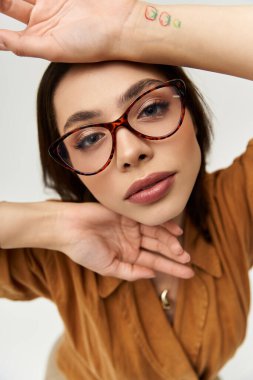 Şık bir genç kadın kendine güvenerek poz veriyor, şık kıyafetlerini ve parlak aksesuarlarını sergiliyor..