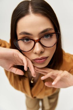 Genç bir kadın, kendine has tarzını canlı giyinerek ve zarif duruşuyla kapalı mekanda sergiliyor..