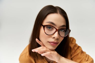 Güzel hatlara sahip genç bir kadın, modaya uygun giyinmiş, çekici ve yetenekli bir şekilde poz veriyor..