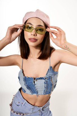 Kendine güveni tam genç bir kadın modaya uygun bir kotla şık bir güneş gözlüğü takıyor..