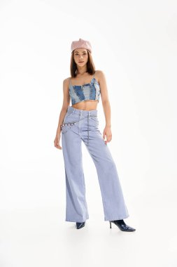 Şık bir genç kadın, parlak bir stüdyoda kendine güvenerek poz veriyor..