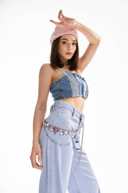 Modayı takip eden genç bir kadın, modaya uygun giysiler içinde, modern stili ve yeteneği somutlaştırıyor..