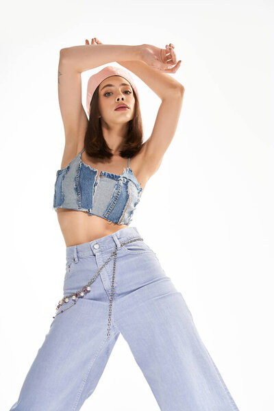 Молодая женщина уверенно демонстрирует свой модный наряд, одновременно принимая выразительную позу..