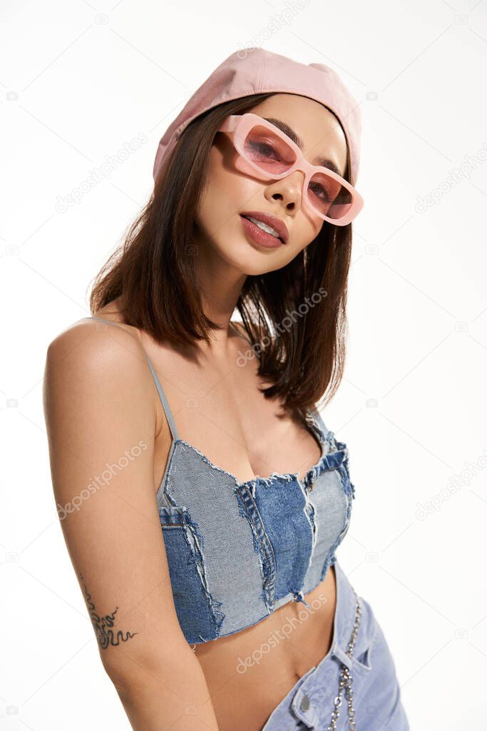 Young woman exudes confidence in trendy attire while posing artistically in a relaxed environment.