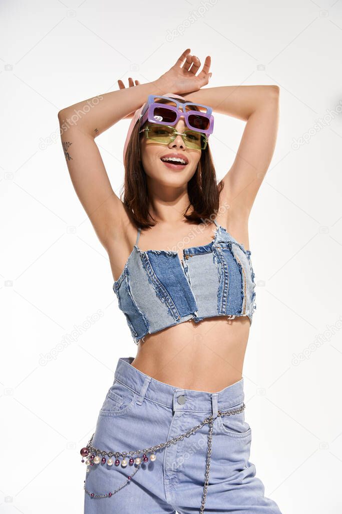 A young, beautiful woman expresses her joy in trendy, colorful attire, radiating confidence and fun.