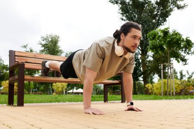 Sakallı, zinde bir genç parkta şınav çekiyor..