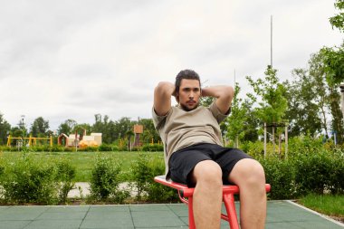 Sportif adam dışarıda egzersiz yapar, çevresindeki doğanın tadını çıkarırken spor yapmaya odaklanır..