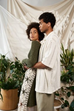 Bir çift, canlı bitkilerin arasında, samimi bir ortamda romantizm yayıyor..