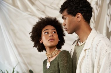 Genç bir çift birbirlerinin gözlerinin içine bakar. Kapalı bir ortamda sevgi ve tarz yayarlar..