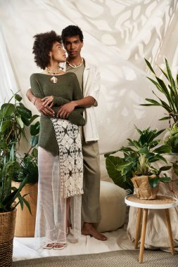 Genç bir çift canlı bir yeşillikle kucaklaşır, sevgi ve tarz yayar..