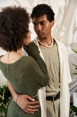 Sevgi dolu çift, yeşil ortamda sıcacık bir ortamda sarılır, sıcaklık ve bağlantı yayar..