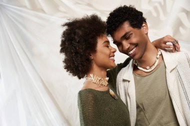 Tarz sahibi bir çift sıcak bir şekilde kucaklaşır, samimi, sevgi dolu bir atmosferde gülümserler..