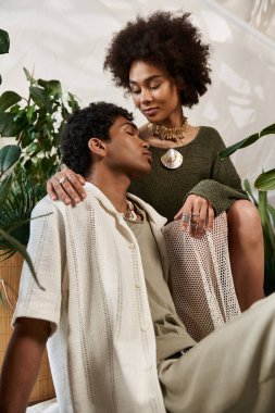 Genç bir çift, canlı bitkiler ve sıcak estetikler arasında romantik bir anı paylaşıyor..