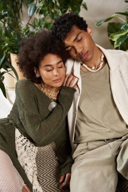 Genç çift, şık ve sakin bir bahçede birbirini kucaklayan hassas bir anın tadını çıkarıyor..