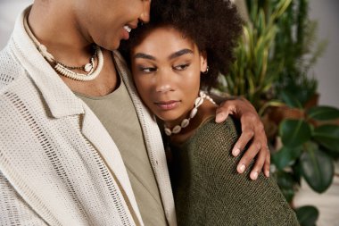 Genç çift yemyeşil ve doğal ışıkta sıcacık kucaklaşır..