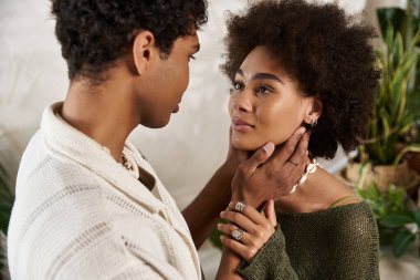 Güzel dekore edilmiş bir yerde, genç bir çift birbirine bakar, sevgi saçar..