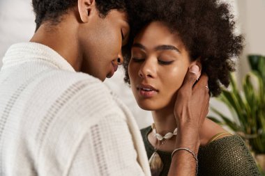 İki genç aşık usulca sarılır, gözleri zarif bir çevrede derin bir sevgiyi yansıtır..