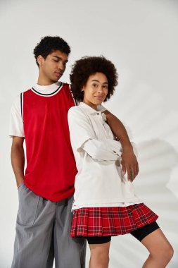 Genç bir çift, minimalist bir ortamda sevgi ve tarz yayarak yakın dururlar..